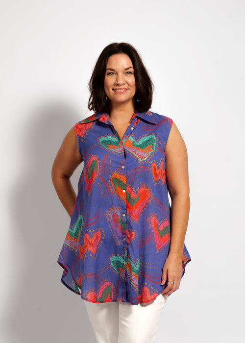 Woman wearing a colorful sleeveless shirt with butterfly design on a white background