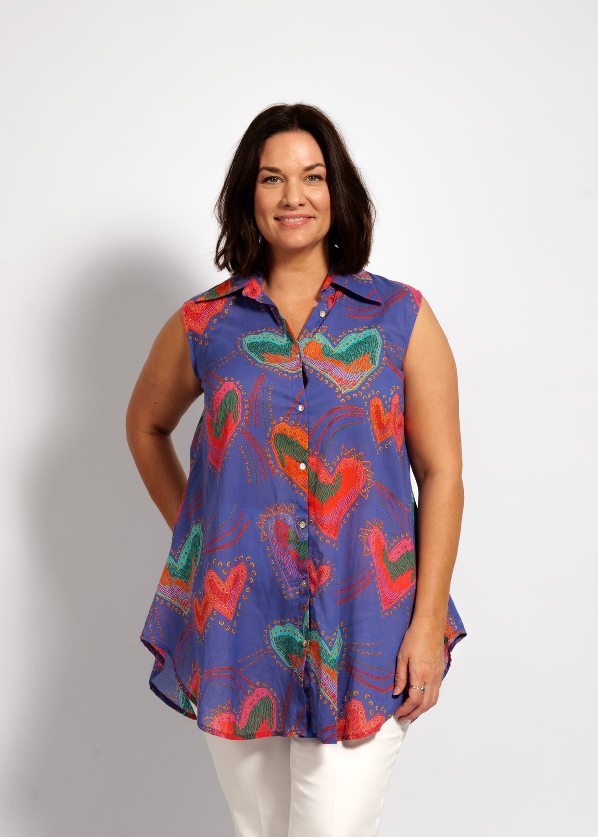 Woman wearing a colorful sleeveless shirt with butterfly design on a white background